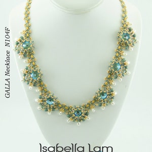 Op de afbeelding: Een delicate ketting met een gouden en groene kralenontwerp met blauwe kristallen accenten. De ketting wordt getoond op een witte mannequinbuste. De tekst "GALLA Necklace N104F" is zichtbaar aan de linkerkant van de afbeelding. De tekst "Isabella Lam New Thinking with Endless Possibilities" is zichtbaar onderaan de afbeelding.