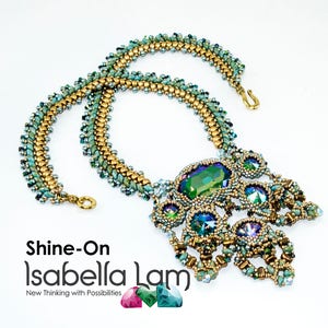 May include: A green and gold beaded necklace with a large green crystal pendant. The pendant is surrounded by smaller crystals and beads. The necklace is called "Shine-On Isabella Lam" and the text "New Thinking with Possibilities" is below the name.