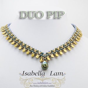 May include: A gold and green beaded necklace with a teardrop pendant. The necklace is called "Duo Pip" and is designed by Isabella Lam.