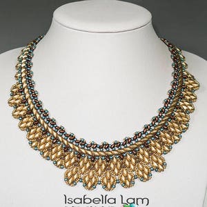 May include: A gold beaded necklace with a leaf-like design. The necklace features gold, teal, and brown beads. The necklace is displayed on a white mannequin. The necklace is a statement piece.