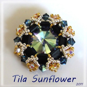 May include: A close-up of a beaded sunflower brooch with a large iridescent crystal in the center. The brooch is made with black, gold, and silver beads.