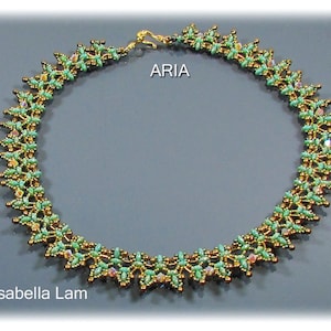 Op de afbeelding: Een groene en gouden kralenketting met een delicaat bloemenpatroon. De ketting heet "ARIA" en is van Isabella Lam.