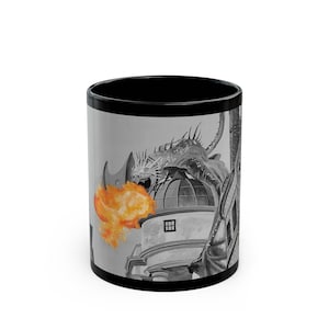 May include: Black coffee mug with a white and gray image of a dragon breathing fire at a building. The dragon is in the foreground and the building is in the background.