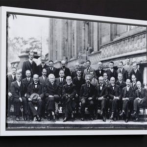 Puede incluir: Una taza de cer&aacute;mica blanca con un asa negra y el texto "But First, Coffee" en negrita negra. La taza se encuentra sobre un fondo borroso, sugiriendo un ambiente acogedor.