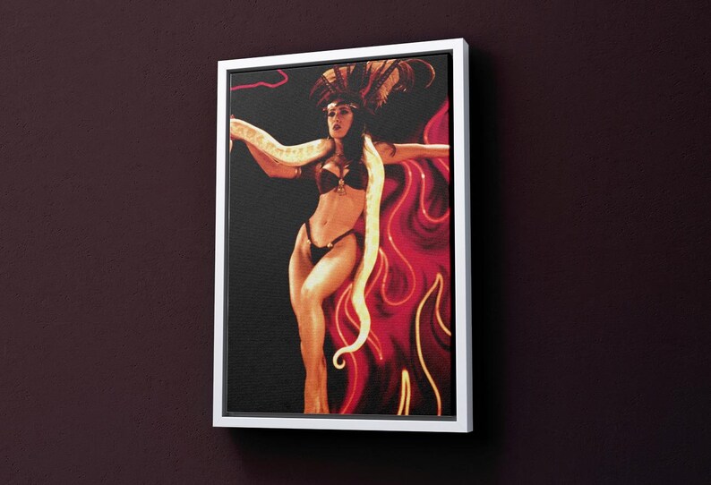 May include: A woman in a red and black costume with a white snake draped around her, posing in front of a red and yellow background.