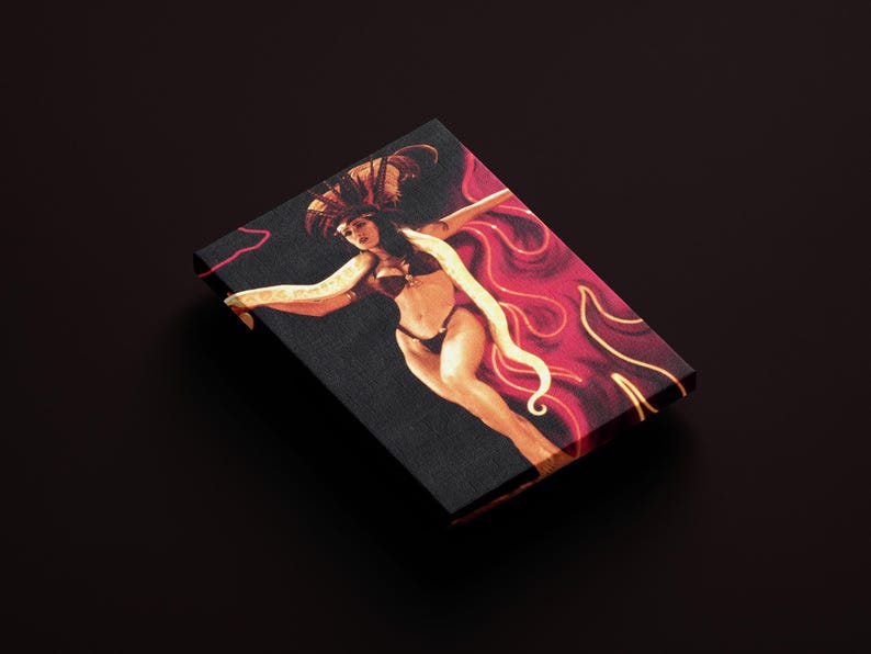 May include: A woman in a red and gold costume with a feathered headdress poses against a background of pink and gold flames.