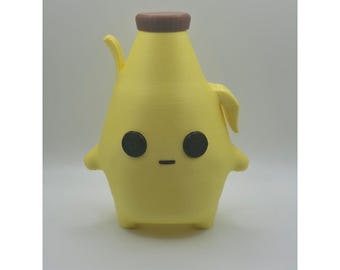May include: A yellow, banana-shaped figurine with a brown cap on top. The figure features two round black eyes and a small horizontal black line for a mouth. It has two small arms extending from the sides and two short legs at the base.
