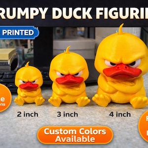Può includere: Tre figurine di anatra scontrosa gialle stampate in 3D con becchi rossi ed espressioni arrabbiate. Dimensioni: 5, 7.6 e 10.2 cm di altezza. Il testo recita "GRUMPY DUCK FIGURINE", "3D PRINTED" e "Custom Colors Available".