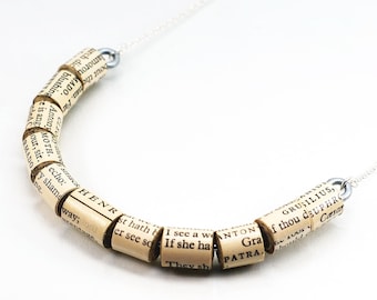 May include: A necklace made of rolled-up pages from a book. The pages are printed with text, including the words "ANTON", "PATRA", "GRUBILIUS", and "Caesar".