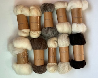 May include: Ten bundles of raw wool fiber, each wrapped in a brown paper label with printed text identifying the breed. The collection includes various shades of white, cream, gray, brown, and black wool, arranged in two rows of five bundles.