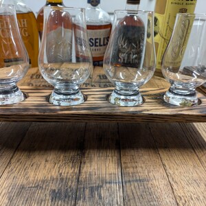 Puede incluir: Una bandeja de servir de madera con cuatro ranuras para vasos. La bandeja est&aacute; hecha de madera reciclada y tiene un acabado marr&oacute;n oscuro. La bandeja es perfecta para servir bebidas o aperitivos.