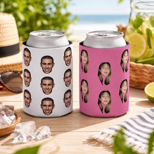 May include: Two can coolers, one white with a pattern of a man's face, and one pink with a pattern of a woman's face. The coolers are designed to keep beverages cold. The background includes a beach scene with a straw hat and sunglasses.