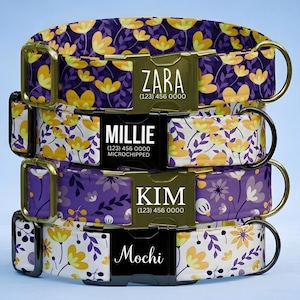 May include: A stack of four pet collars featuring floral patterns in purple, yellow, and white. Each collar has a metal or plastic buckle engraved with names and phone numbers: ZARA (123) 456 0000, MILLIE (123) 456 0000 MICROCHIPPED, KIM (123) 456 0000, and Mochi.