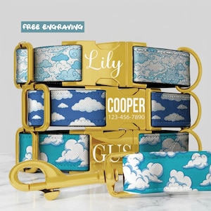 May include: Three pet collars with gold-tone metal buckles and hardware. Each collar features a blue and white cloud pattern. The buckles are engraved with the names Lily, COOPER, and GUS, with a phone number included on the middle buckle.