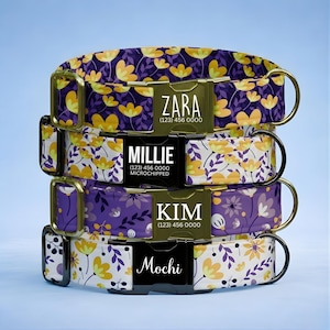 May include: Four personalized dog collars stacked, each with a different floral pattern in purple, yellow, and white. Each collar has a name tag with a pet's name and a phone number. The names are Zara, Millie, Kim, and Mochi.