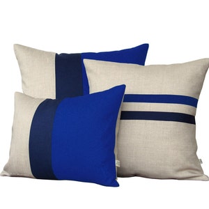 Puede incluir: Tres almohadas decorativas con base de tejido de lino y rayas azules y azul marino. Las almohadas est&aacute;n apiladas con la m&aacute;s grande en la parte inferior y la m&aacute;s peque&ntilde;a en la parte superior.