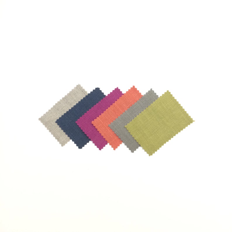 May include: Six fabric swatches in different colors and textures. The swatches are arranged in a fan shape, with the lightest color at the top and the darkest color at the bottom. The colors are beige, navy blue, purple, orange, gray, and green.