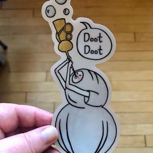 Puede incluir: Un personaje de dibujos animados blanco con un cuerpo redondo y una cara pequeña sopla burbujas desde un tubo dorado. El personaje sostiene el tubo con una mano y tiene un globo de diálogo sobre su cabeza que dice "Dood Dood".