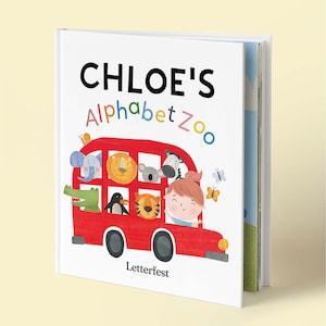 May include: A hardcover children's book titled CHLOE'S ALPHABET ZOO with a white cover featuring a red bus filled with illustrated animals including an elephant, lion, koala, zebra, crocodile, penguin, and tiger, plus a child and butterflies.