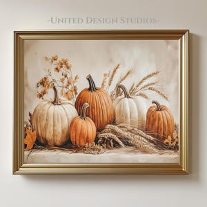 May include: A framed artwork featuring a still life of pumpkins and wheat. The pumpkins vary in size and color, ranging from white to orange. Wheat stalks and autumn leaves are also included in the composition. The frame is gold, and the text "-UNITED DESIGN STUDIOS-" is at the top.