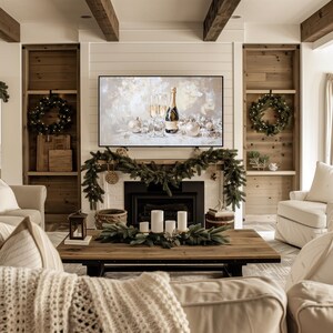Pode incluir: Uma sala de estar com uma lareira decorada com uma guirlanda de vegeta&ccedil;&atilde;o. Uma televis&atilde;o acima da lareira exibe uma pintura de uma garrafa de champanhe e duas ta&ccedil;as. Uma mesa de centro em frente &agrave; lareira &eacute; decorada com um centro de mesa de vegeta&ccedil;&atilde;o e velas.