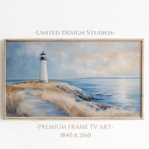 May include: A framed painting of a white lighthouse on a rocky coast with a blue ocean and a cloudy sky. The painting is in a light wood frame. The text "UNITED DESIGN STUDIOS" and "PREMIUM FRAME TV ART - 3840 X 2160" is printed below the image.