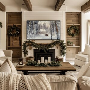May include: A living room with a white fireplace mantel decorated with a garland of pine branches and white lights. A flat screen TV is mounted above the fireplace. The fireplace is decorated with candles and a wooden bowl. The room is decorated with a white couch and a coffee table.