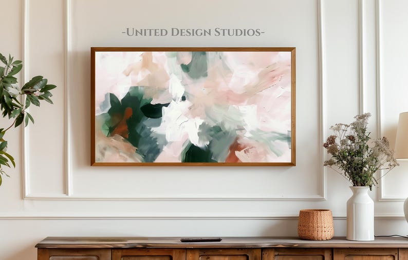 May include: Abstract art print with a pink, white, and green color scheme. The print is framed in a light wood frame and is hanging on a white wall.