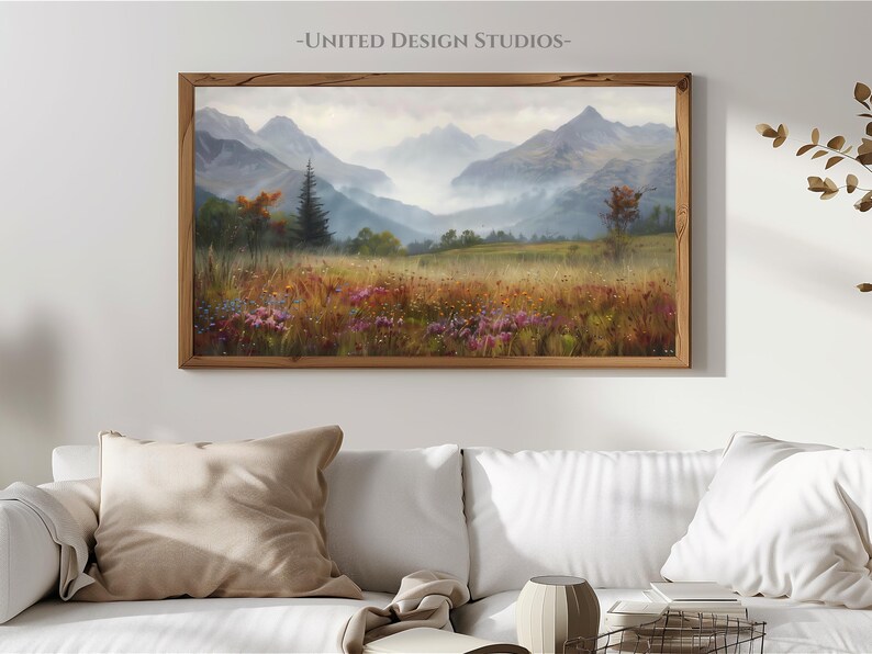 May include: A framed painting of a mountain landscape with a misty valley and a field of wildflowers in the foreground. The mountains are in the background and are covered in fog. The painting is in a wooden frame.