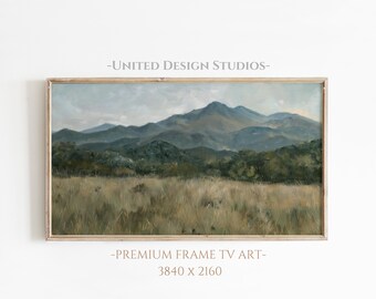 May include: A framed painting depicting a landscape with a mountain range in the background and a field of grass in the foreground. The painting is in a light wood frame and features a muted colour palette of greens, blues, and browns.