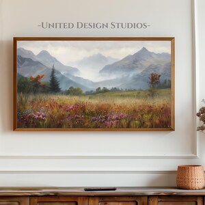 May include: A framed painting of a misty mountain landscape with a valley in the foreground. The painting features a variety of colors, including green, brown, and blue. The mountains are covered in fog, and the valley is filled with wildflowers.
