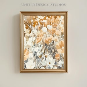 Puede incluir: Una impresión floral en acuarela enmarcada. La obra presenta un campo de flores en tonos blancos, melocotón y marrón. El marco es de color dorado, y el texto "-UNITED DESIGN STUDIOS-" está en la parte superior.