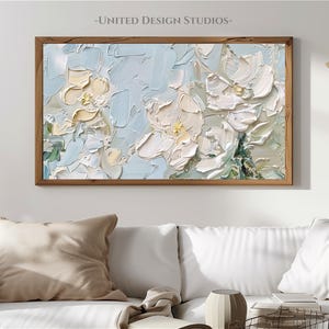 K&ouml;nnte beinhalten: Ein gerahmtes abstraktes Gem&auml;lde im impasto-Stil. Das Gem&auml;lde zeigt wei&szlig;e und hellblaue Blumen auf hellblauem Hintergrund.