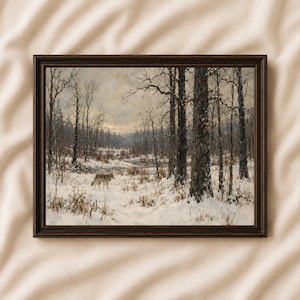 May include: A framed landscape painting depicting a lone wolf walking through a snow-covered forest clearing. The scene features bare trees, a frozen stream, and a muted, overcast sky, all enclosed within a dark brown wooden frame.