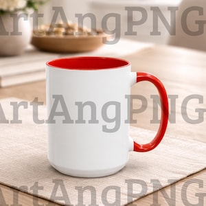 Puede incluir: Una taza de cerámica blanca con interior y asa rojos. La taza está sobre un mantel individual beige sobre una mesa de madera. La taza está vacía y lista para ser llenada.