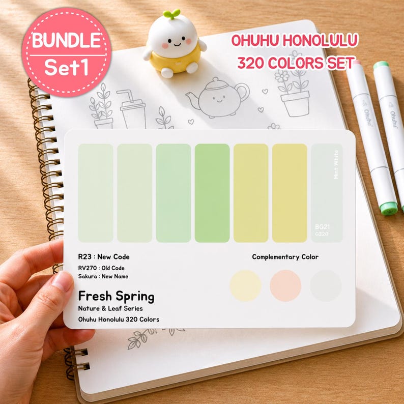 May include: A spiral-bound notebook with a color palette card featuring shades of green and yellow, labeled "Fresh Spring." The card is part of the Ohuhu Honolulu 320 Colors Set. A small, yellow figurine and two white markers are also visible.