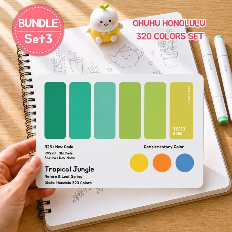May include: A color palette card from the Ohuhu Honolulu 320 Colors Set, featuring shades of green and complementary colors. The card is labeled "Tropical Jungle" and includes color codes. Two white markers and a small figurine are also present.
