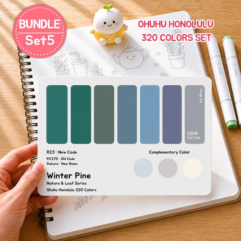 May include: A color palette card from the Ohuhu Honolulu 320 Colors Set, featuring shades of green, blue, and gray. The card includes the text "Winter Pine" and "Nature & Leaf Series". The card is held over a spiral-bound notebook.