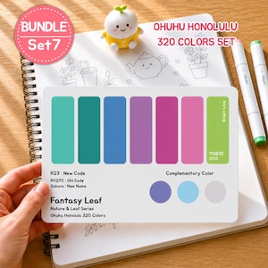 May include: A color palette card from the Ohuhu Honolulu 320 Colors Set, featuring a range of colors from teal to pink, with the text "Fantasy Leaf." The card is held over a spiral-bound notebook. A small, yellow figurine and markers are also visible.