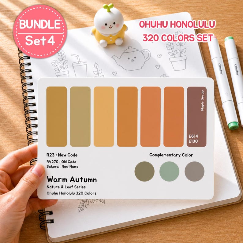 May include: A set of Ohuhu Honolulu 320 Colors markers with a Warm Autumn color palette. The image shows a color chart with various shades of yellow, orange, and brown, along with a small figurine and a notebook. The text "BUNDLE Set 4" is visible.