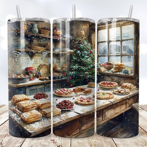 May include: A stainless steel tumbler with a winter scene featuring a kitchen with a Christmas tree, a window, and a table full of pastries. The tumbler is decorated with a snowy effect.