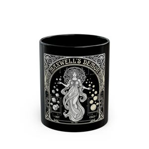 May include: Black ceramic mug featuring an illustration of a woman in a flowing gown, with the text "Maxwell's Demon" in an ornate frame. The design includes geometric shapes and the words "Hot" and "Cold".