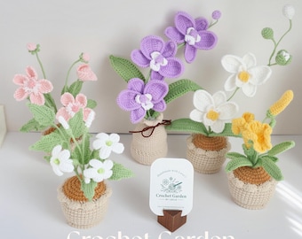 May include: Four crocheted flower arrangements in pots. The flowers are white, pink, purple, and yellow. The pots are beige and brown. A sign reads "Crochet Garden by Layla".