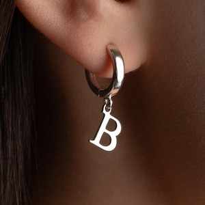 May include: A set of three ceramic mugs with a speckled, matte finish. The mugs are in shades of cream, light grey, and dark grey. Each mug has a simple, minimalist design, ideal for coffee or tea.