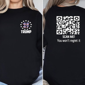 May include: Black sweatshirt with a white design on the front that says "45 47 TRUMP" and a QR code on the back with the text "SCAN ME! You won't regret it."