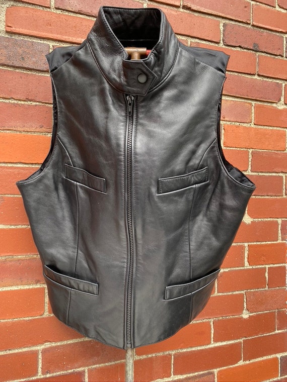 She wore a black leather vest, fitted and sexy, un