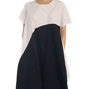 Könnte beinhalten: Ein weißes und schwarzes Kleid mit geometrischem Muster. Das Kleid hat kurze Ärmel und eine lockere Passform.