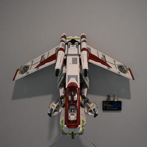 以下が含まれることがあります： 壁に飾られた白、赤、緑のレゴスターウォーズV-4X-Dスキー・スピダーと2体のミニフィギュア
