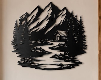 May include: A black metal wall art piece featuring a detailed silhouette of a mountain range, a dense forest of pine trees, a winding river, and a small cabin. The design is cut from a single sheet of metal with intricate negative space details.