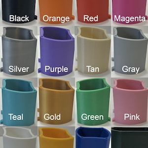 May include: A collection of 16 colorful, 3D-printed containers. Colors include black, orange, red, magenta, silver, purple, tan, gray, teal, gold, green, pink, white, yellow, navy blue, and forest green. Each container has the color name printed on it.